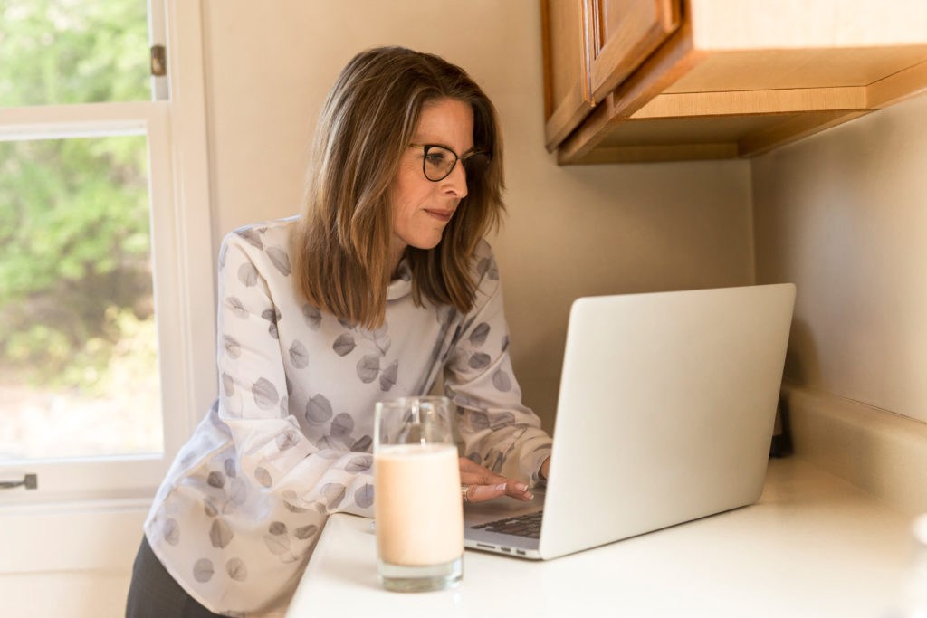 Woman Using Gray Laptop Computer In Kitchen 1251833 Woman Using Gray Laptop Computer In Kitchen 1251833